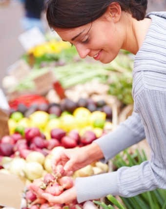 Happy young lady shopping vegetables
