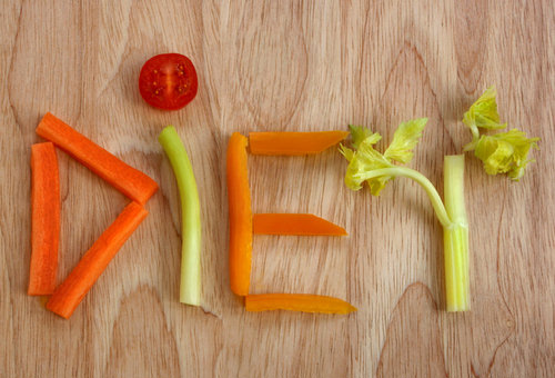 The word diet spelt out in vegetables on a wooden board.