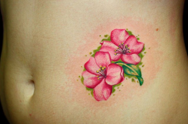 Pink flower tattoo on midriff