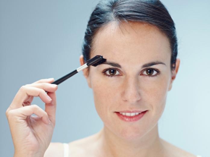 close up of woman brushing eyebroW