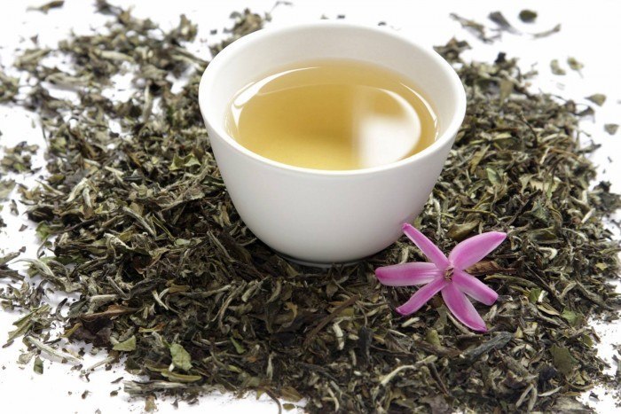 Cup of white tea with dry leaves