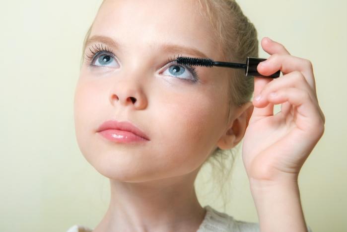 child applying mascara
