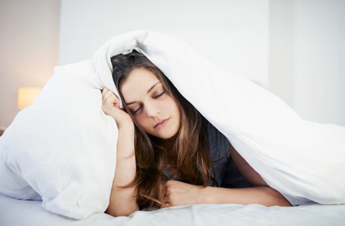 young woman looking tired in bed