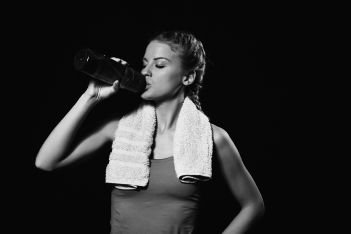 girl drinking water after workout