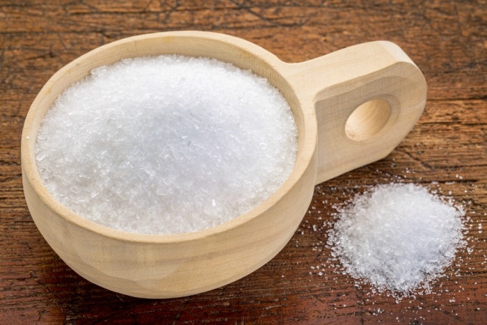 Magnesium sulfate Epsom salts in a rustic wooden scoop relaxing bath concept