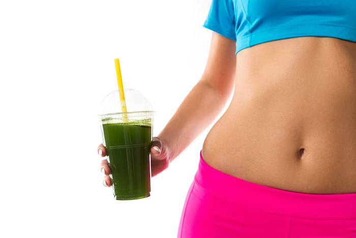 Woman holding green smoothie for weight loss