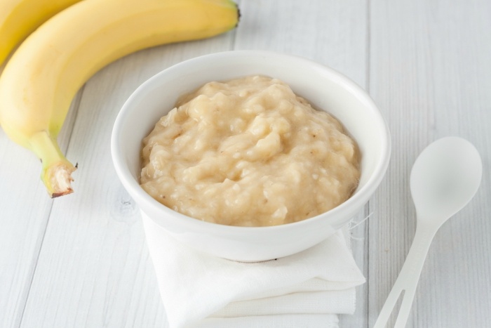 mashed banana in white bowl baby food horizontal image