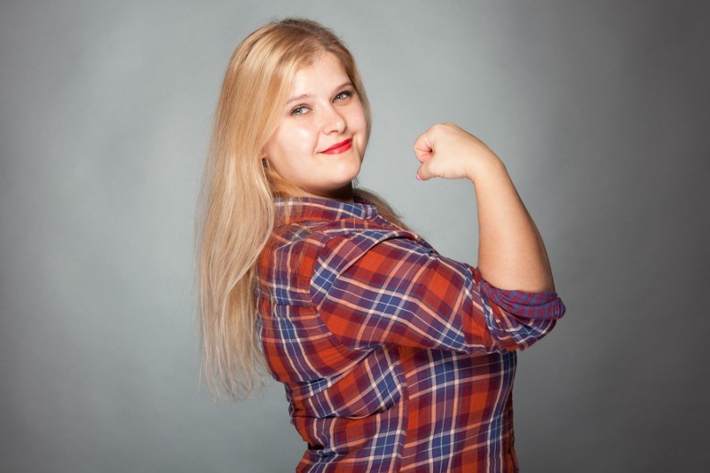 Beautiful fat woman in plaid shirt showing biceps