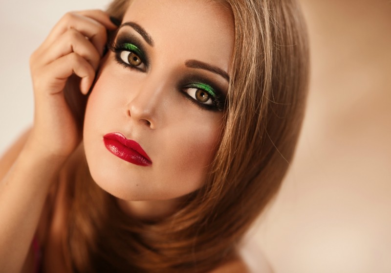 Beautiful model with bright colorful makeup red lips and beautiful hair looking straight