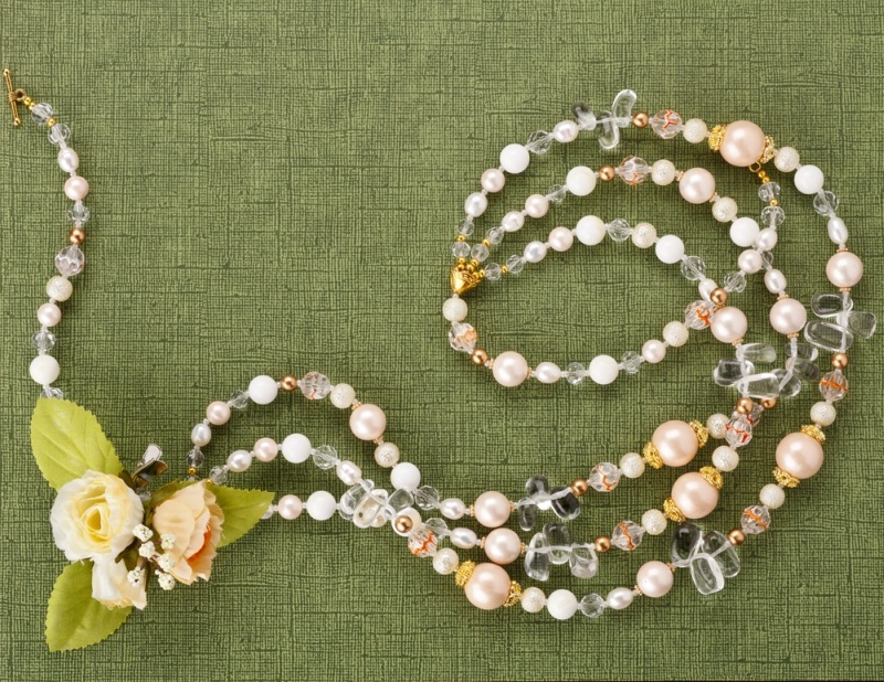 Blank with a necklace and flowers on green background