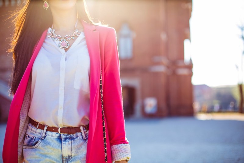 Fashion women in pink blazer with the sun in the background