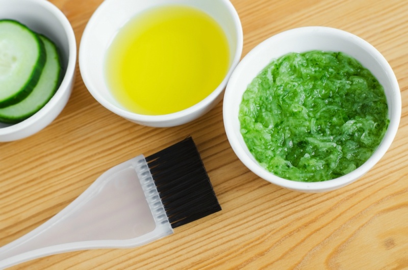 Grated cucumber and olive oil in a small ceramic bowls for preparing natural facial mask. Homemade cosmetics.