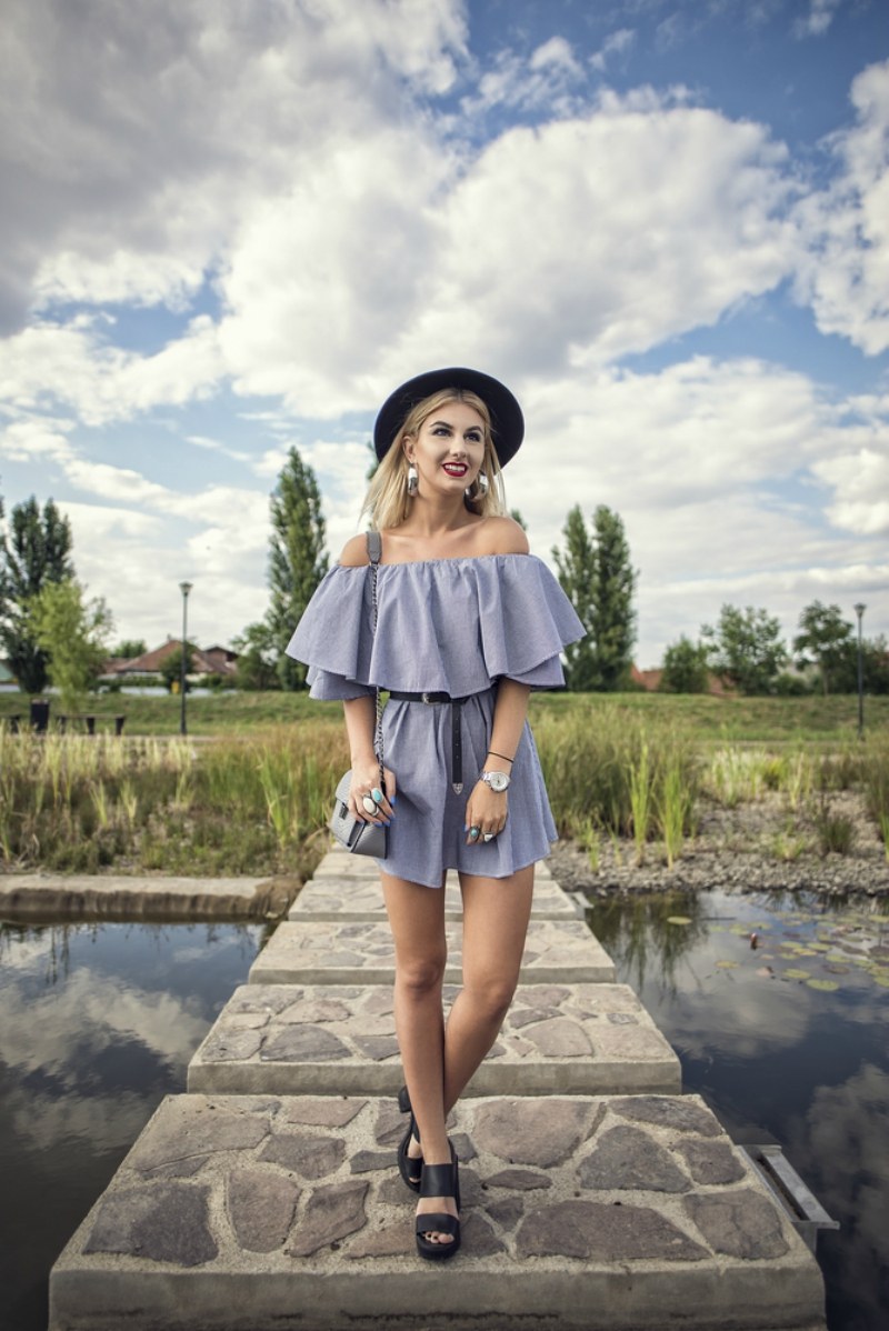 Outdoor shoot of young beautiful, fashionable, playful, chic, woman posing on a small bridge