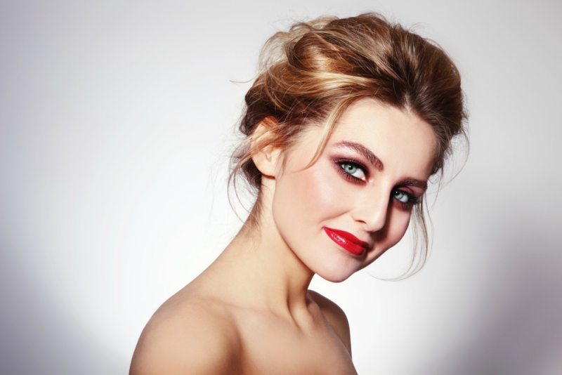 Portrait of young beautiful glamorous woman with stylish make-up and messy hair bun