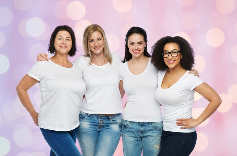 friendship, diverse, body positive and people concept - group of happy different size women in white t-shirts hugging over rose quartz and serenity holidays lights background