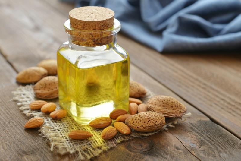 Almond oil in bottle on wooden background