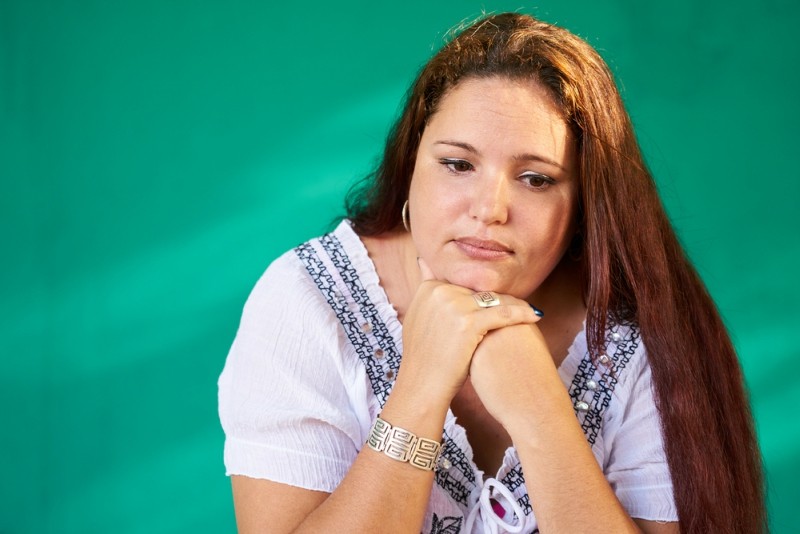 Cuban people and emotions, portrait of sad overweight latina looking down. Depressed fat hispanic young woman from Havana, Cuba.