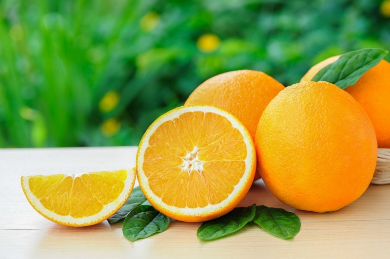 Orange, half of orange,Oranges on the wooden table on the green blurred background