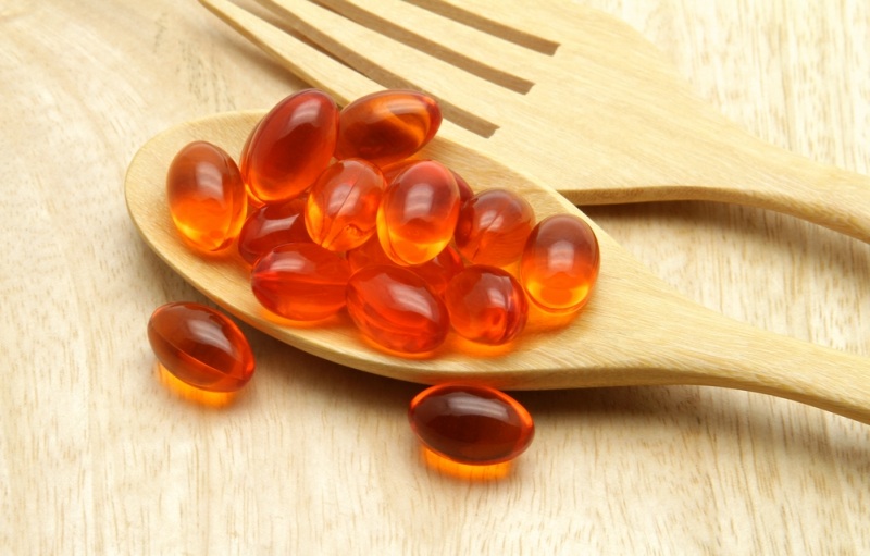 Vitamin, Coenzyme Q10 on the wooden spoon for anti-aging.