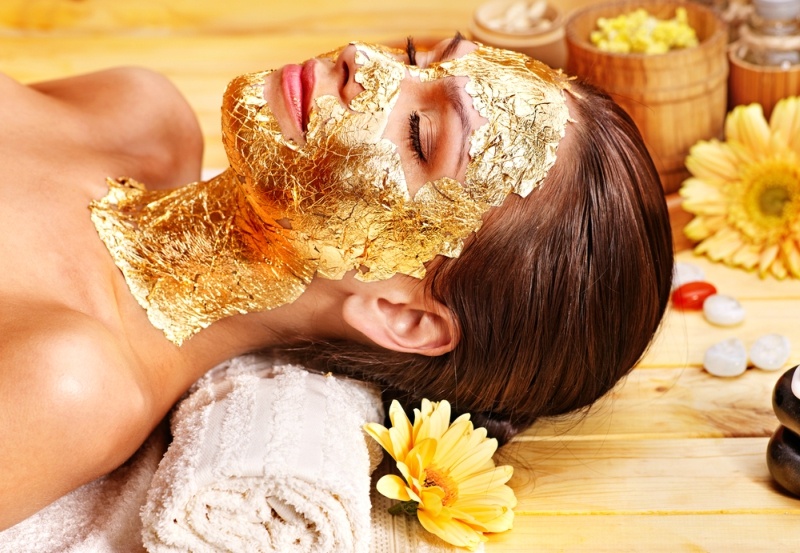 Woman getting gold facial mask
