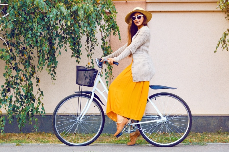 Young pretty beautiful woman riding her white retro hipster bike,wearing stylish vintage clothes sunglasses and straw hat, fashion fall autumn portrait of elegant lady having fun outdoor.
