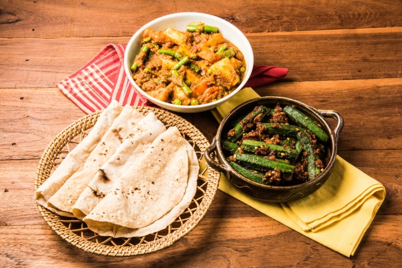 bhindi masala or bhendi masala or ladies finger fry with mixed veg in red curry with indian roti chapati fulka paratha indian bread, indian spicy food
