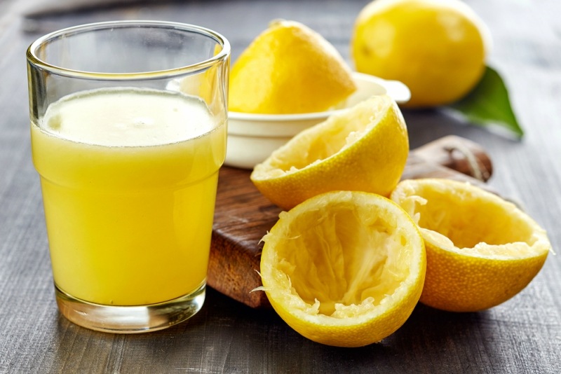 glass of lemon juice on wooden table