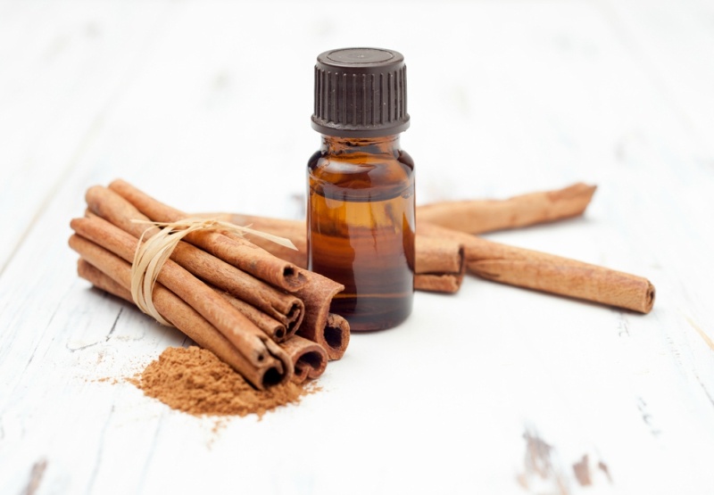 ground cinnamon, essential oil and cinnamon sticks cinnamon on a white background