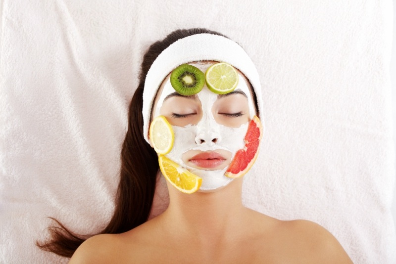 woman with face mask and fruit slices on face