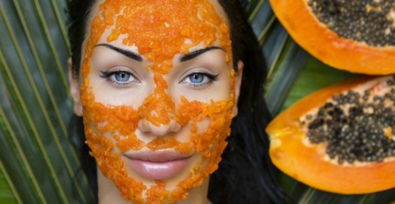 Beautiful caucasian Woman Having fresh Papaya natural facial mask apply Papaya Peeling Skin care and Wellness outdoors Facial vitamin mask of papaya slices at spa salon antioxidant cosmetic