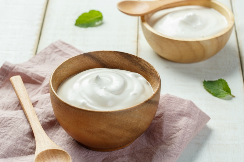 Homemade yogurt or sour cream in a wooden bowl