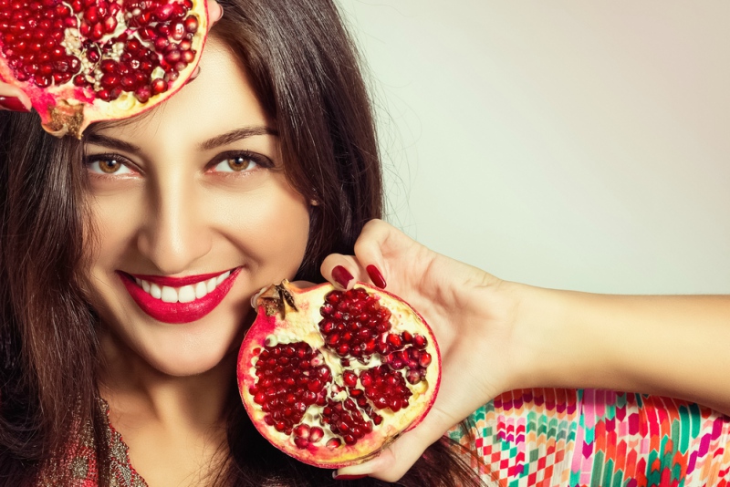 Portrait of a beautiful young woman with a pomegranate.