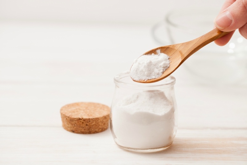 sea salt, starch in the jar and wooden spoon for recipes of cosmetics at home on a white wooden background