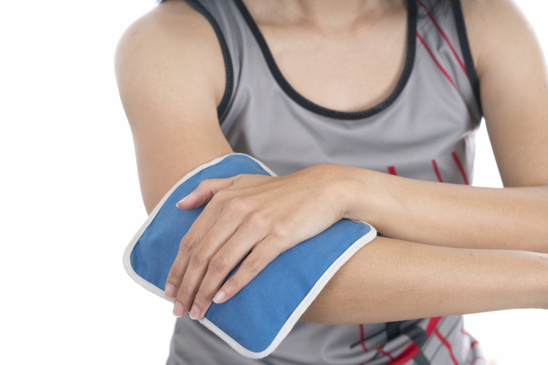 woman putting an ice pack on her elbow pain